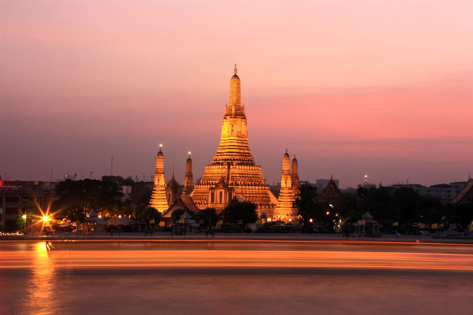 Wat Arun lit in gold at dusk, reflected in the river, one of the top things to do in Bangkok