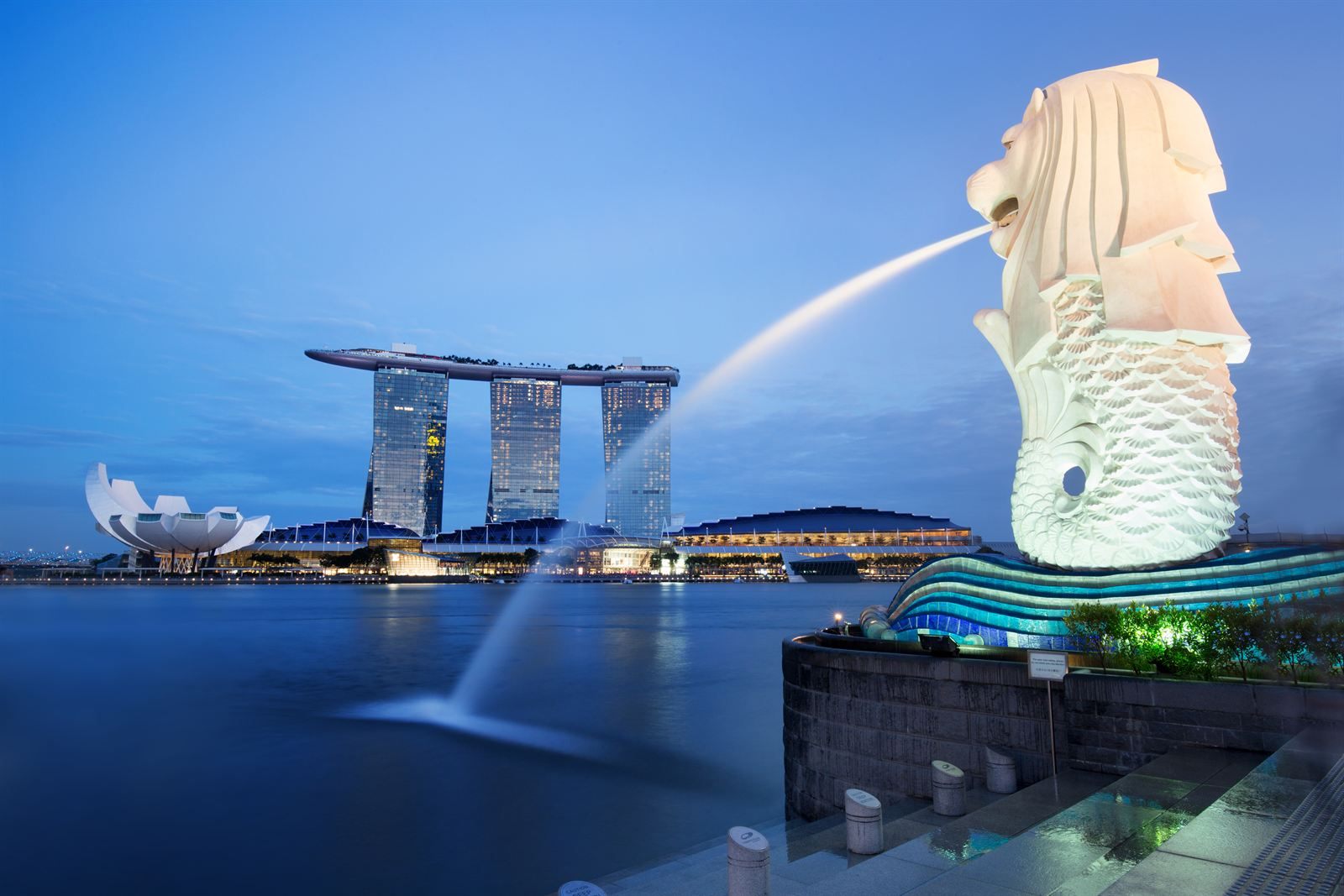 The Merlion statue spouting water across Marina Bay toward Marina Bay Sands in Singapore